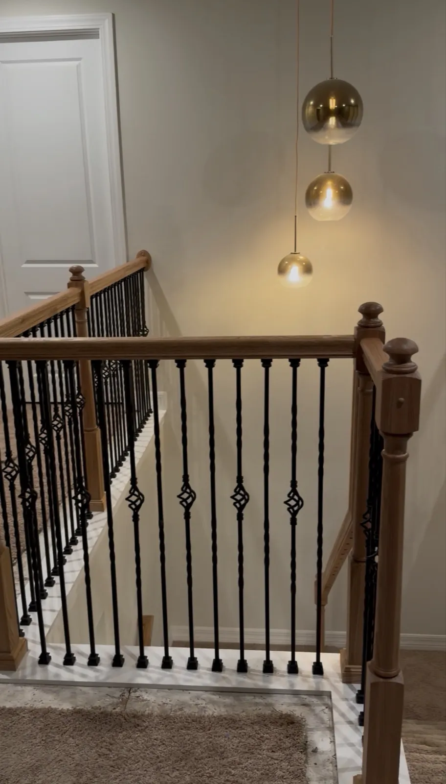 Oak stair rails with black iron balusters by New Design Pro in an Orlando home