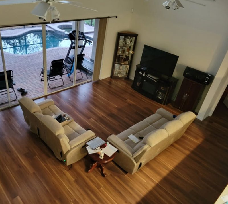 Living room from the loft before, with dark laminate flooring