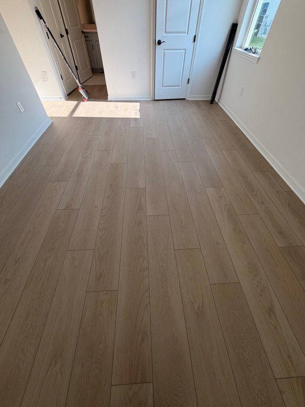 New construction bedroom with light oak LVP