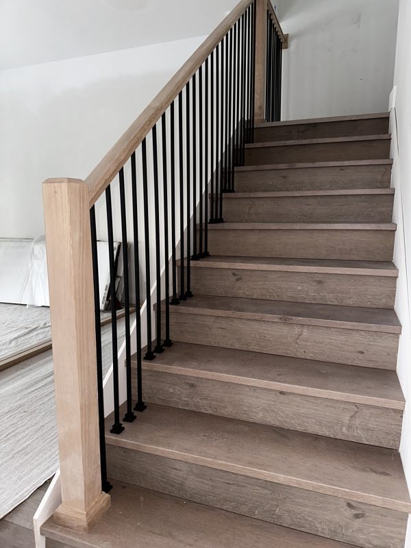LVP stairs with a new wood rail and black balusters