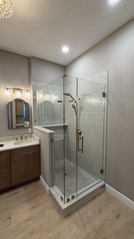 Finished walk-in shower with frameless glass and gold fixtures